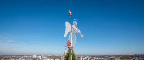 Der Engel wird auf den größten Weihnachtsbaum der Welt gesetzt. 