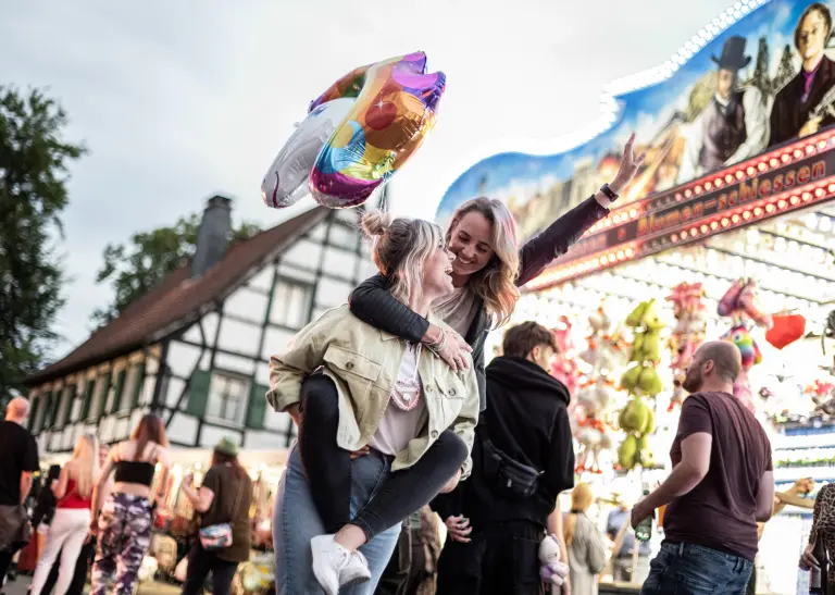 Zwei junge Frauen auf einer Kirmes.