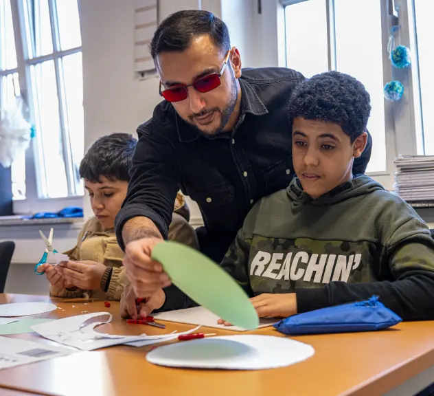 Betreuer Muhammed Akdag spricht mit einem Kind im VHS Zentrum Nord (Eving).