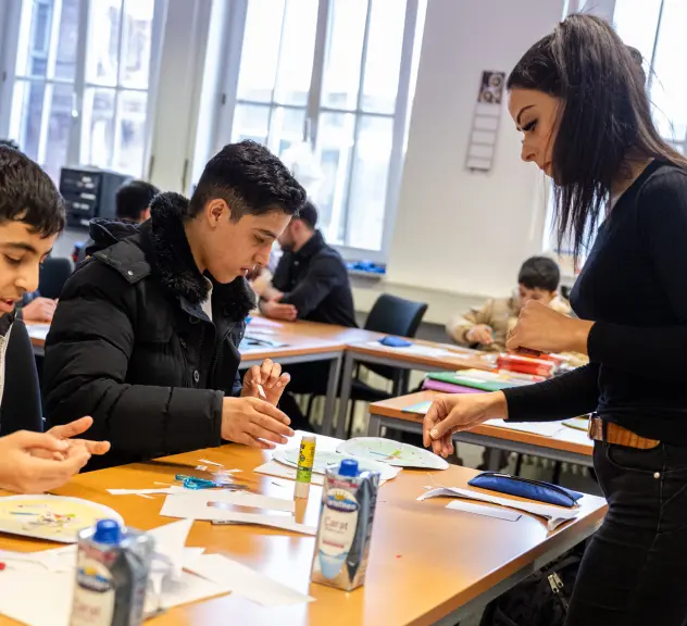 Betreuerin Farida Aouam erklärt Kindern im VHS Zentrum Nord (Eving) die Jahreszeiten-Uhr.