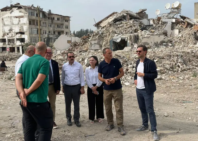 Mehrere Personen stehen in den Trümmern der Altstadt Ankaya.