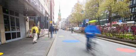 Eine asphaltierte Straße, auf der bunte Kreise angebracht sind. Es handelt sich um die Kampstraße.