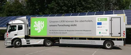 Silberner Truck mit der Aufschrift "Unseren LKW können Sie überholen, unsere Forschung nicht."