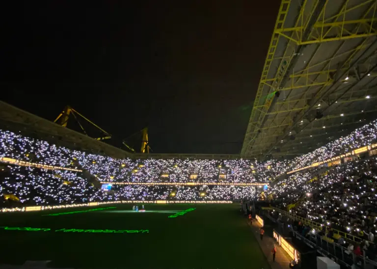 Blick in die Ränge des Stadions mit singenden Besuchenden