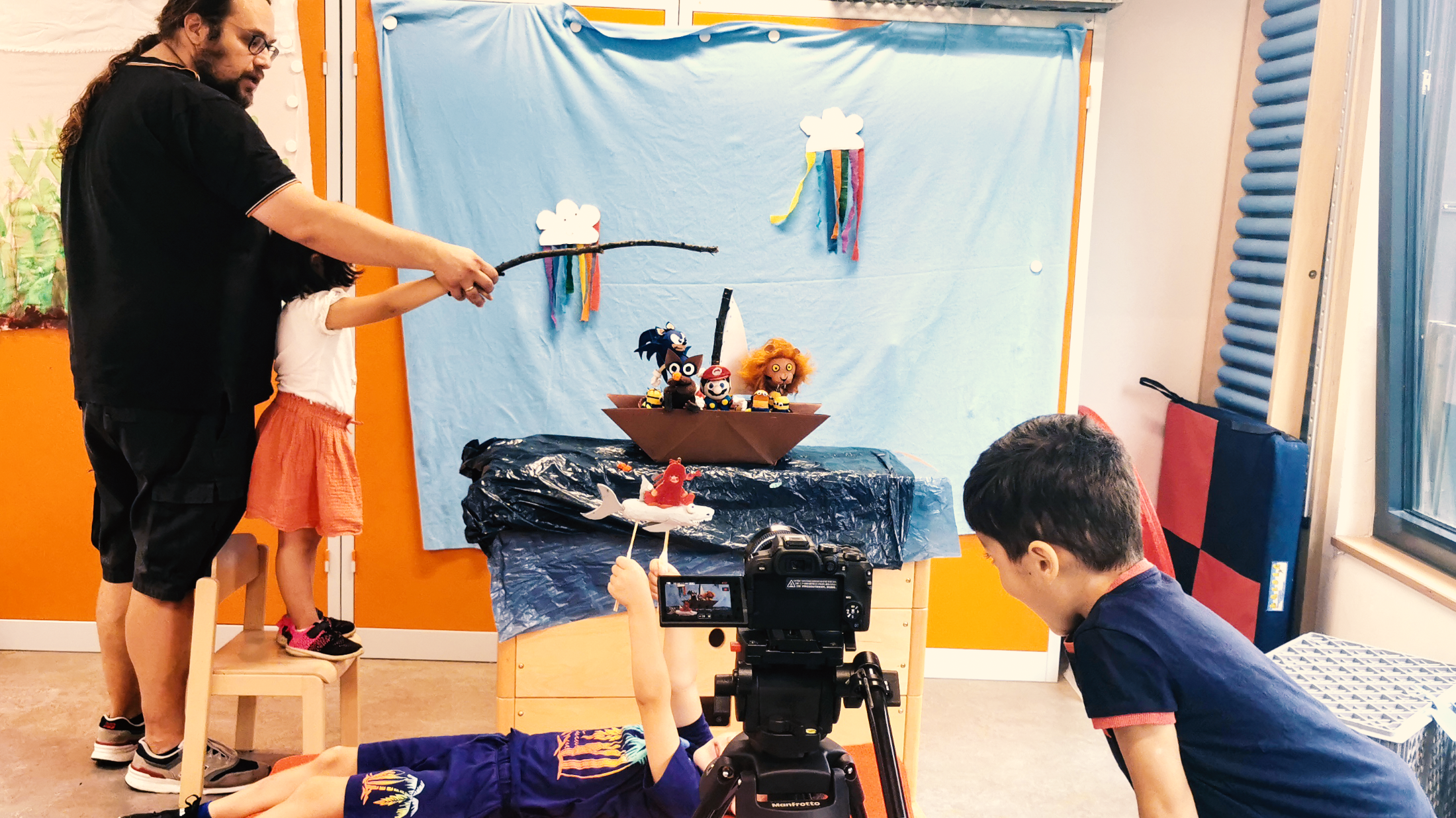 Kinder und Betreuer bauen eine Filmkulisse auf