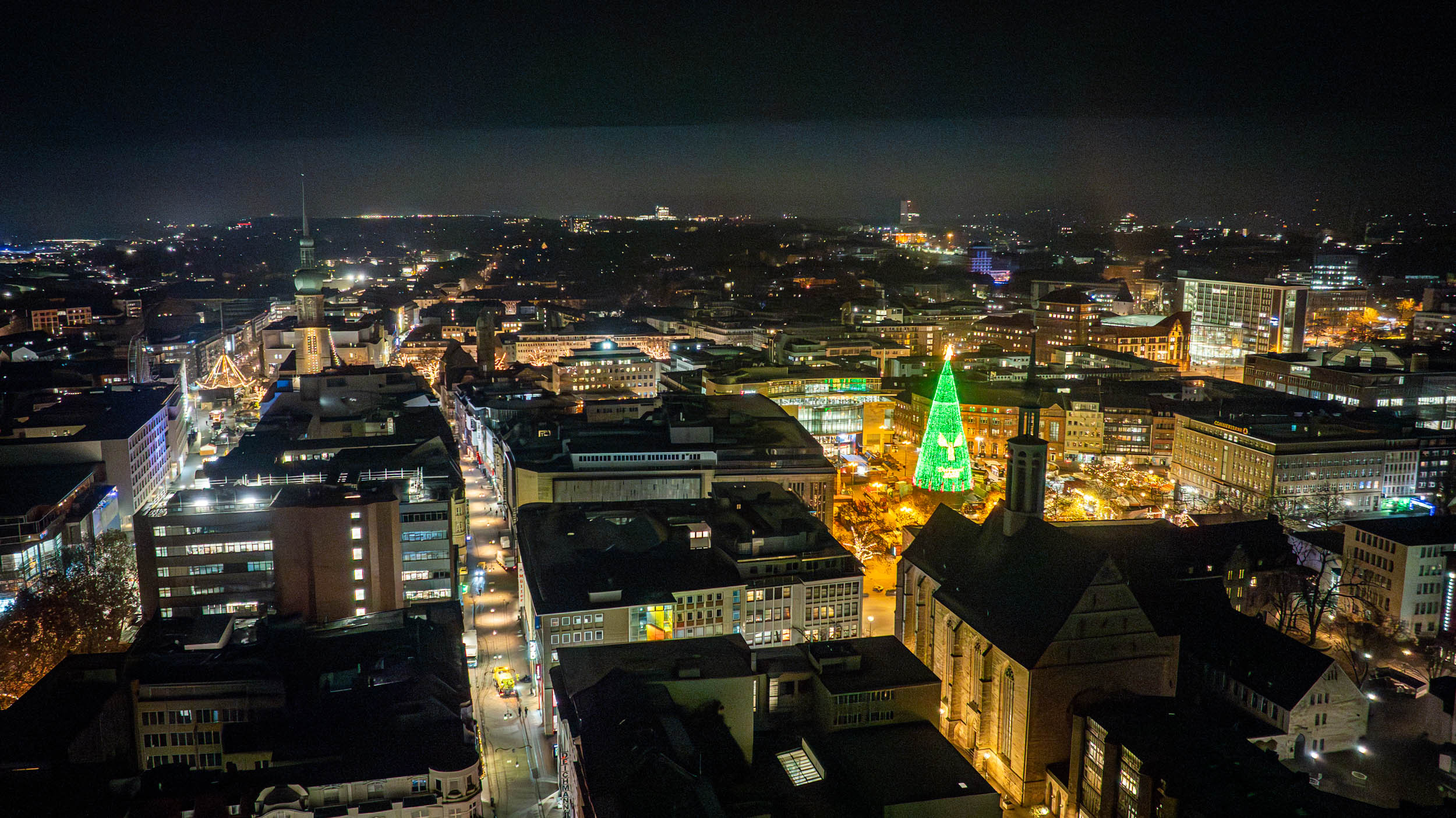 Aus der Vogelperspektive ist der Hellweg zu sehen. Der Dortmunder Weihnachtsbaum erstrahlt in einem Grün.