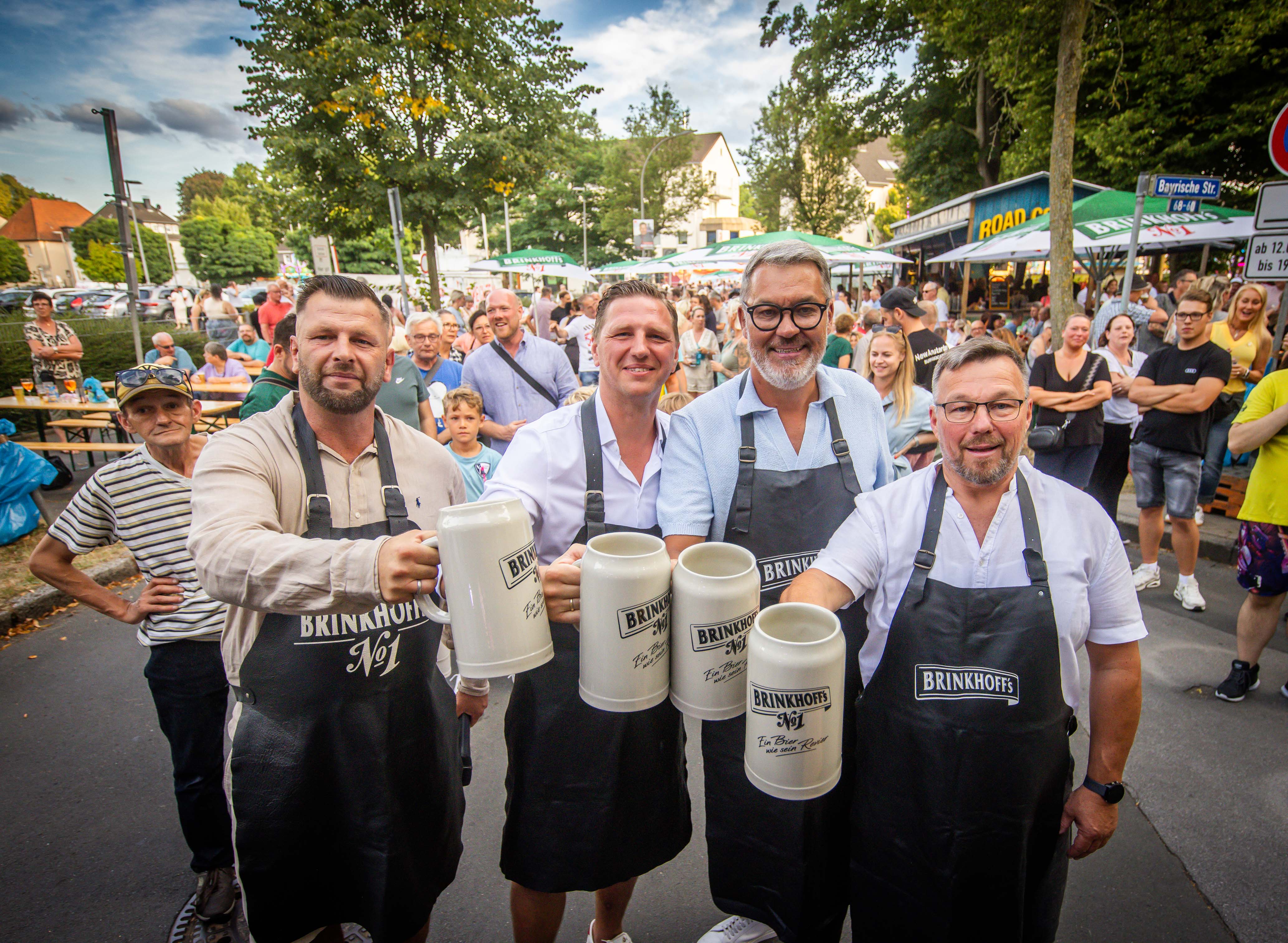 OB Westphal (zweiter von rechts) stößt bei der Eröffnung mit einem Bierkrug und drei weiteren Personen an.