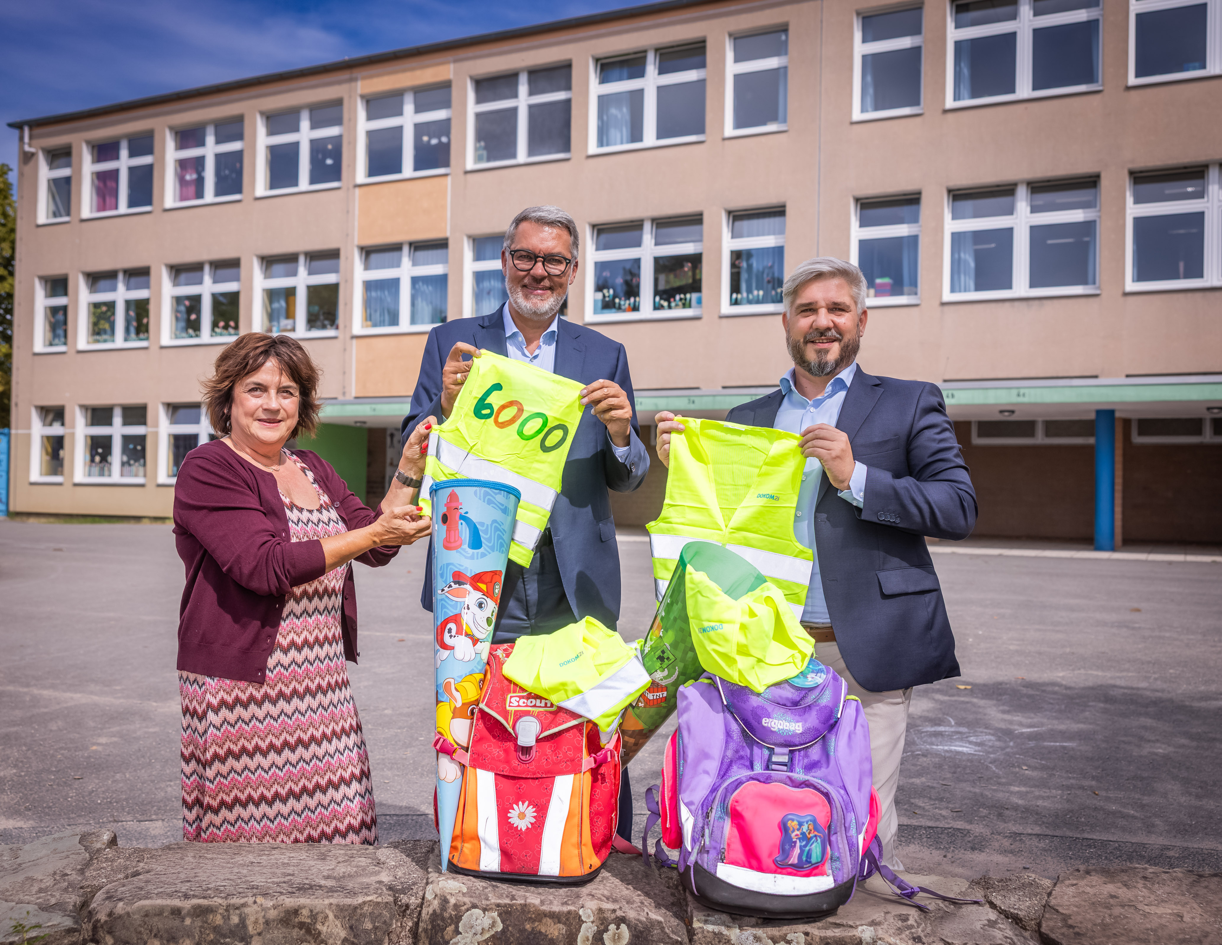 Jutta Portugall, Schulleiterin und Sprecherin der Grundschulen, Oberbürgermeister Thomas Westphal und DOKOM21-Geschäftsführer Marko Iaconisi halten gelbe Warnwesten