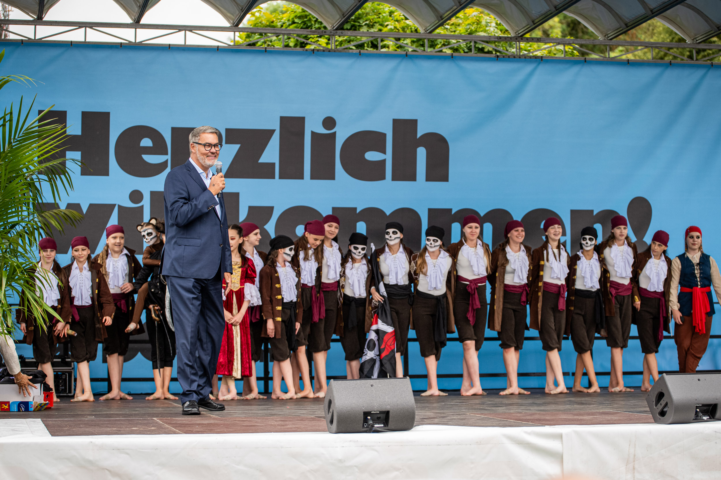 OB Westphal auf einer Bühne, hinter ihm geschminkte Kinder.