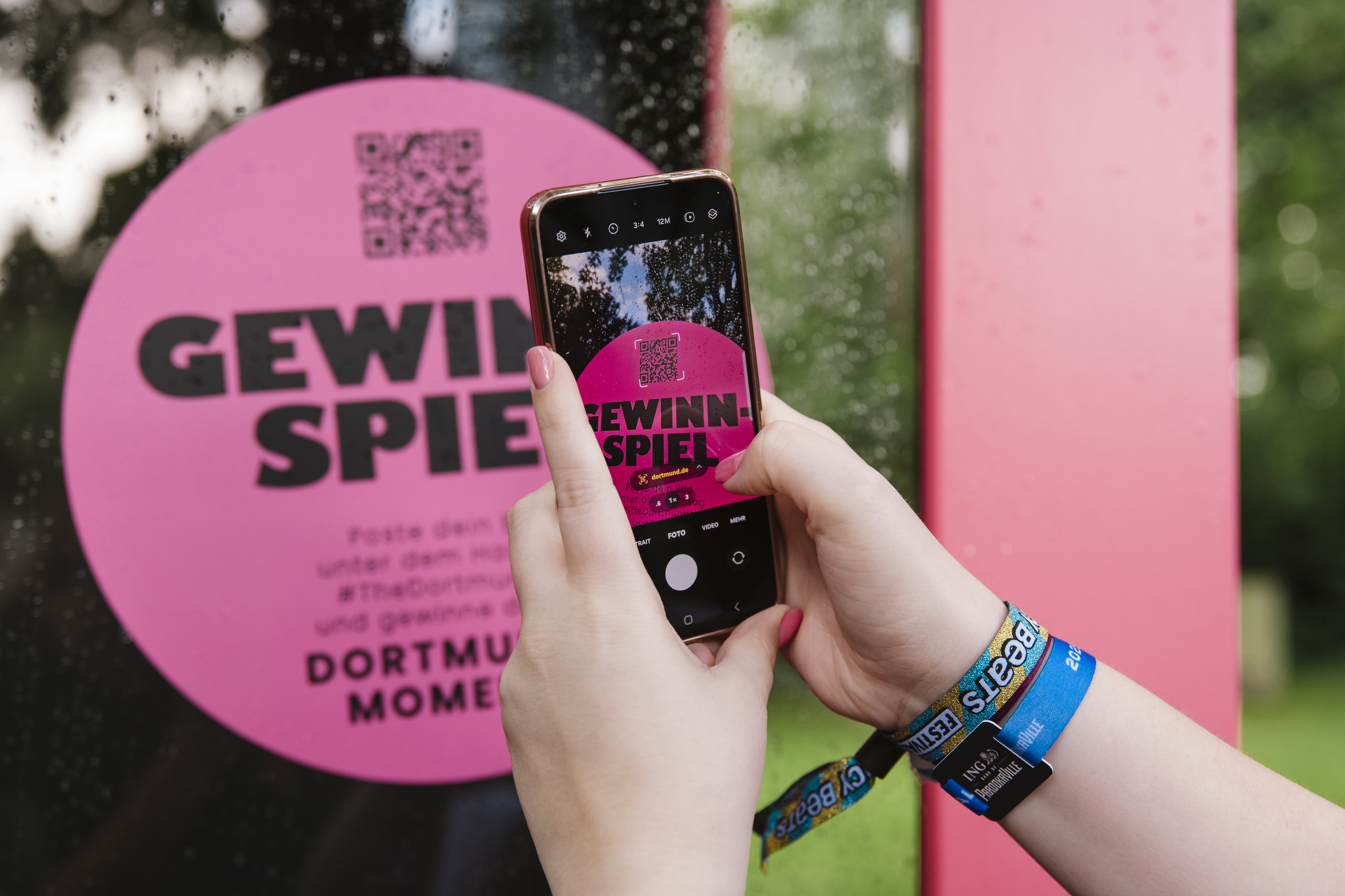 Eine Frau scannt mit dem Mobiltelefon einen QR Code zu einem Gewinnspiel