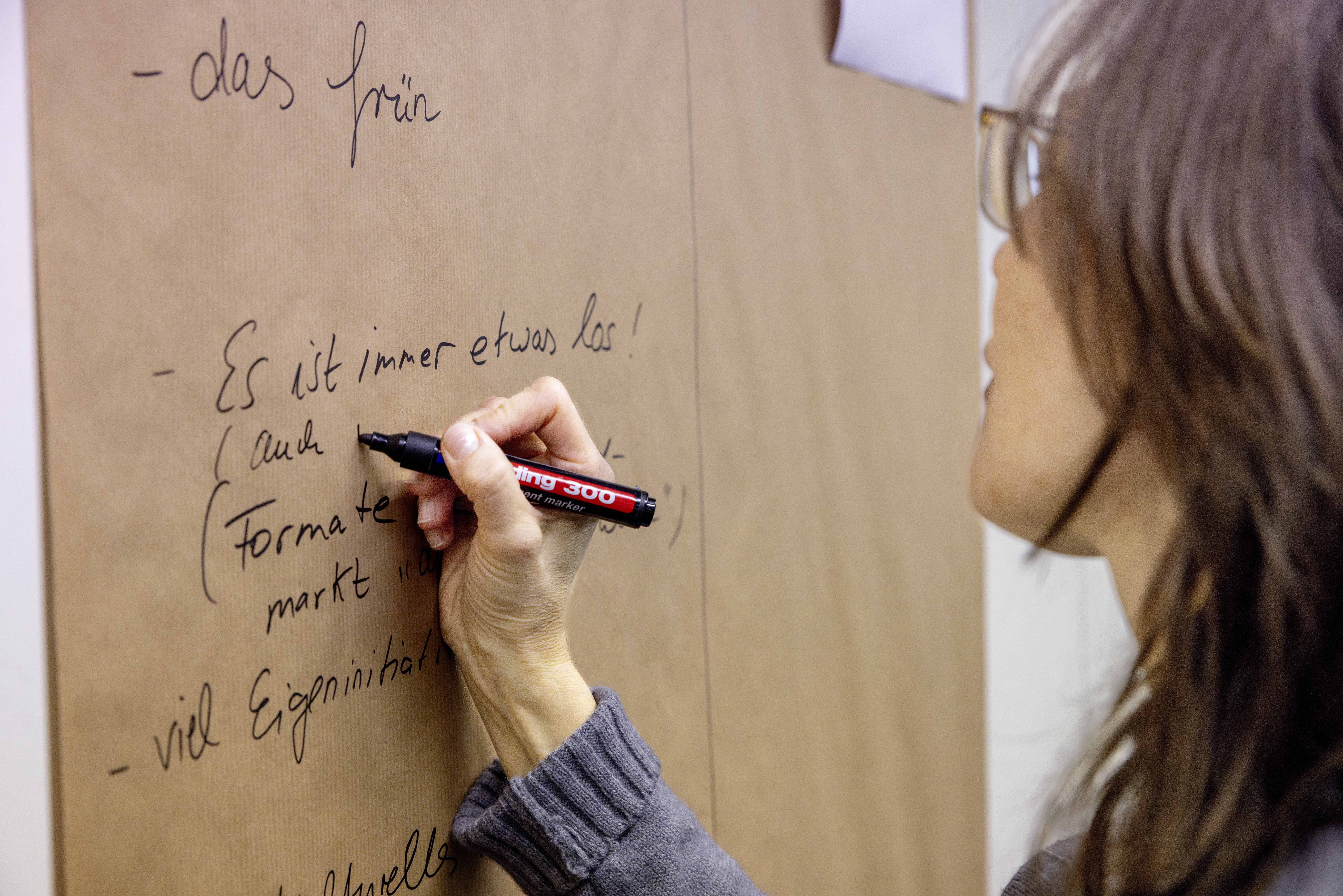 Eine Frau schreibt auf eine Leinwand.