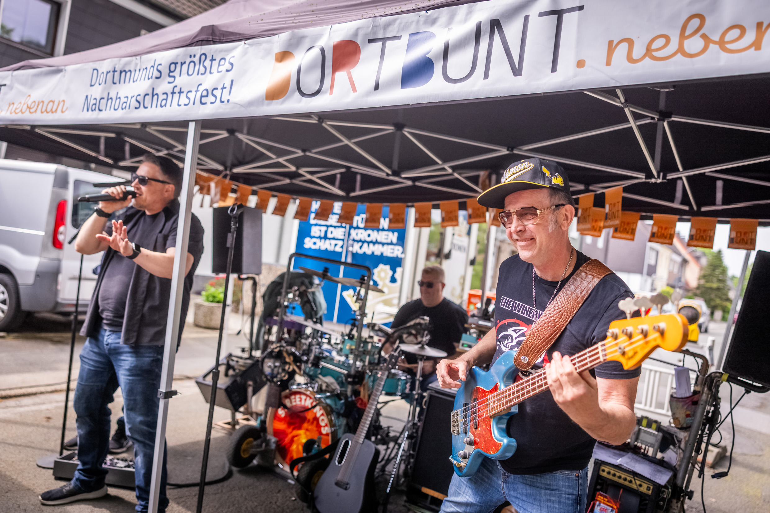 Eine Band, im Vordergrund spielt ein Mann Gitarre.