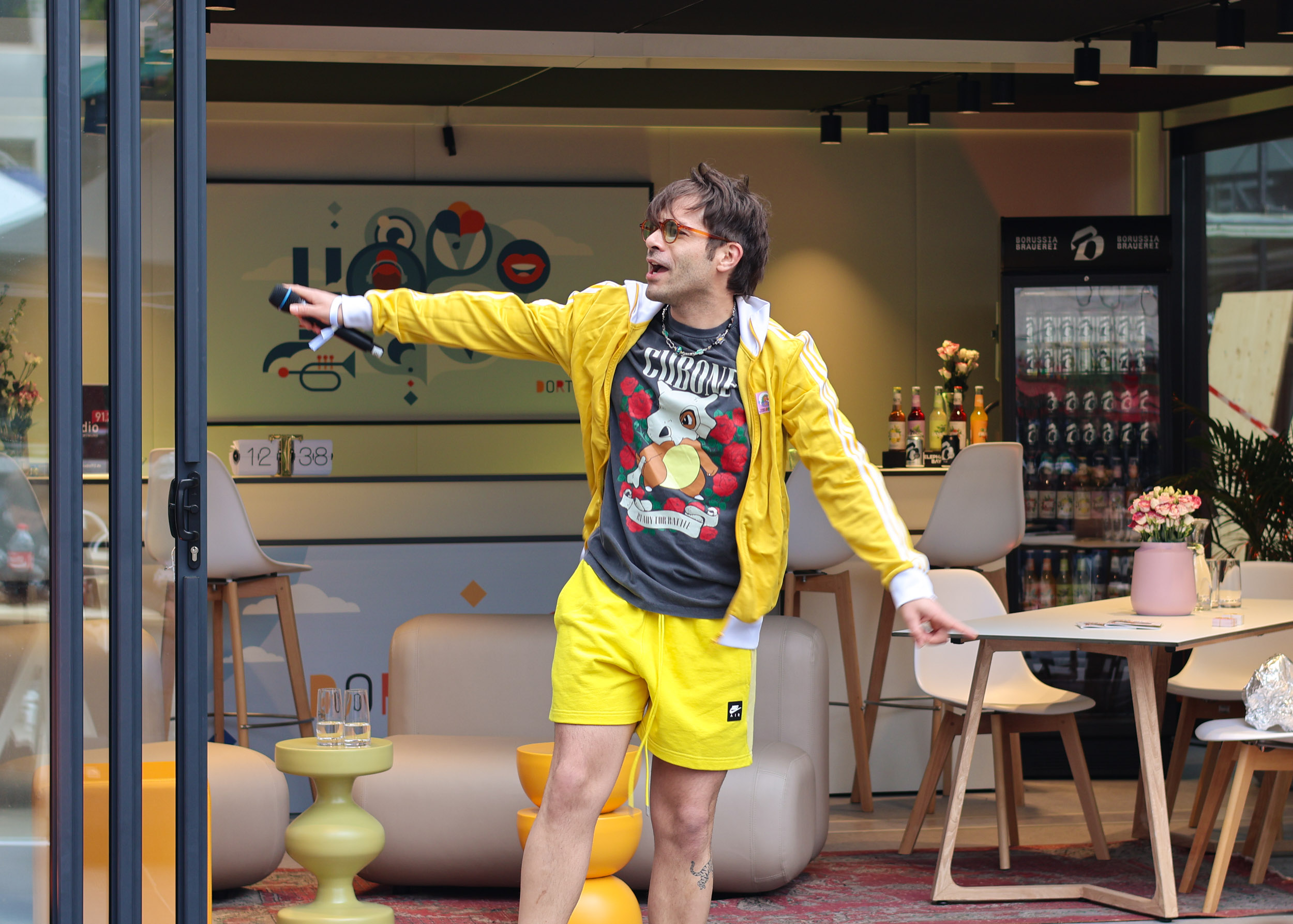 Sänger der Band Honigkuchenpferde mit einer gelben Jacke und gelben Hose.