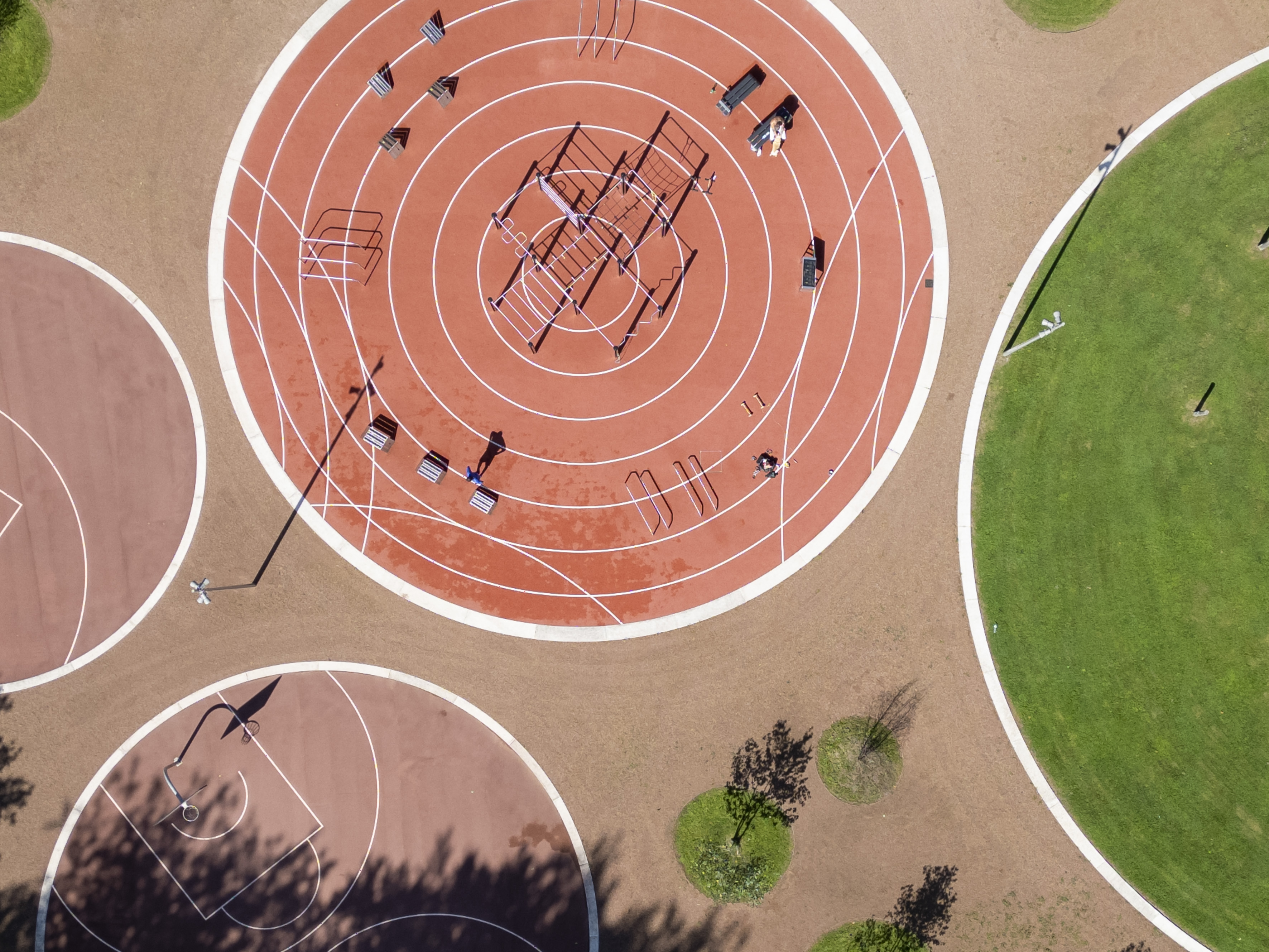 Drohnenaufnahme benachbarter kreisrunder Sportflächen.