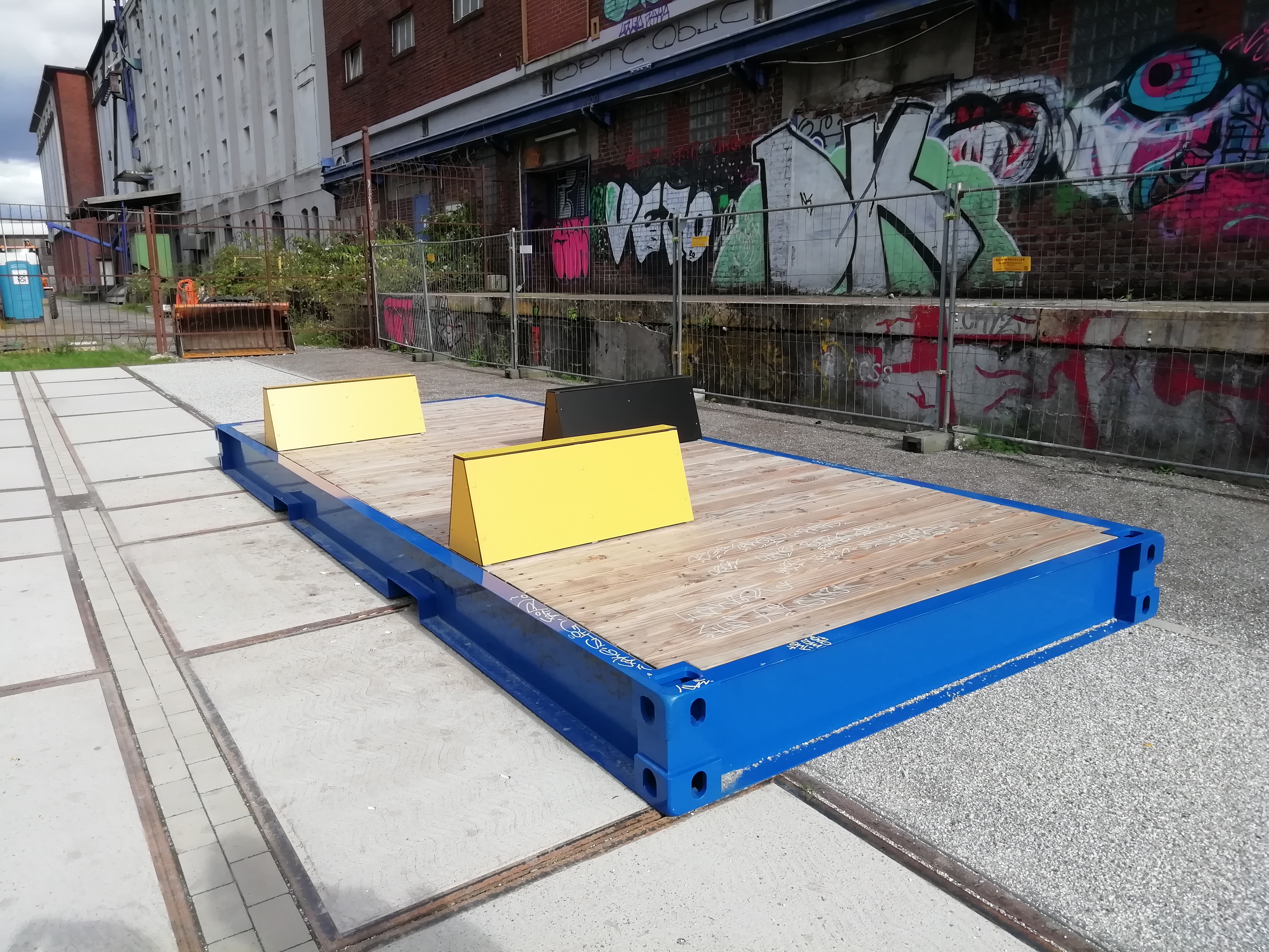 Sitz- und Liegelegenheit mit gelben und blauen Elementen.