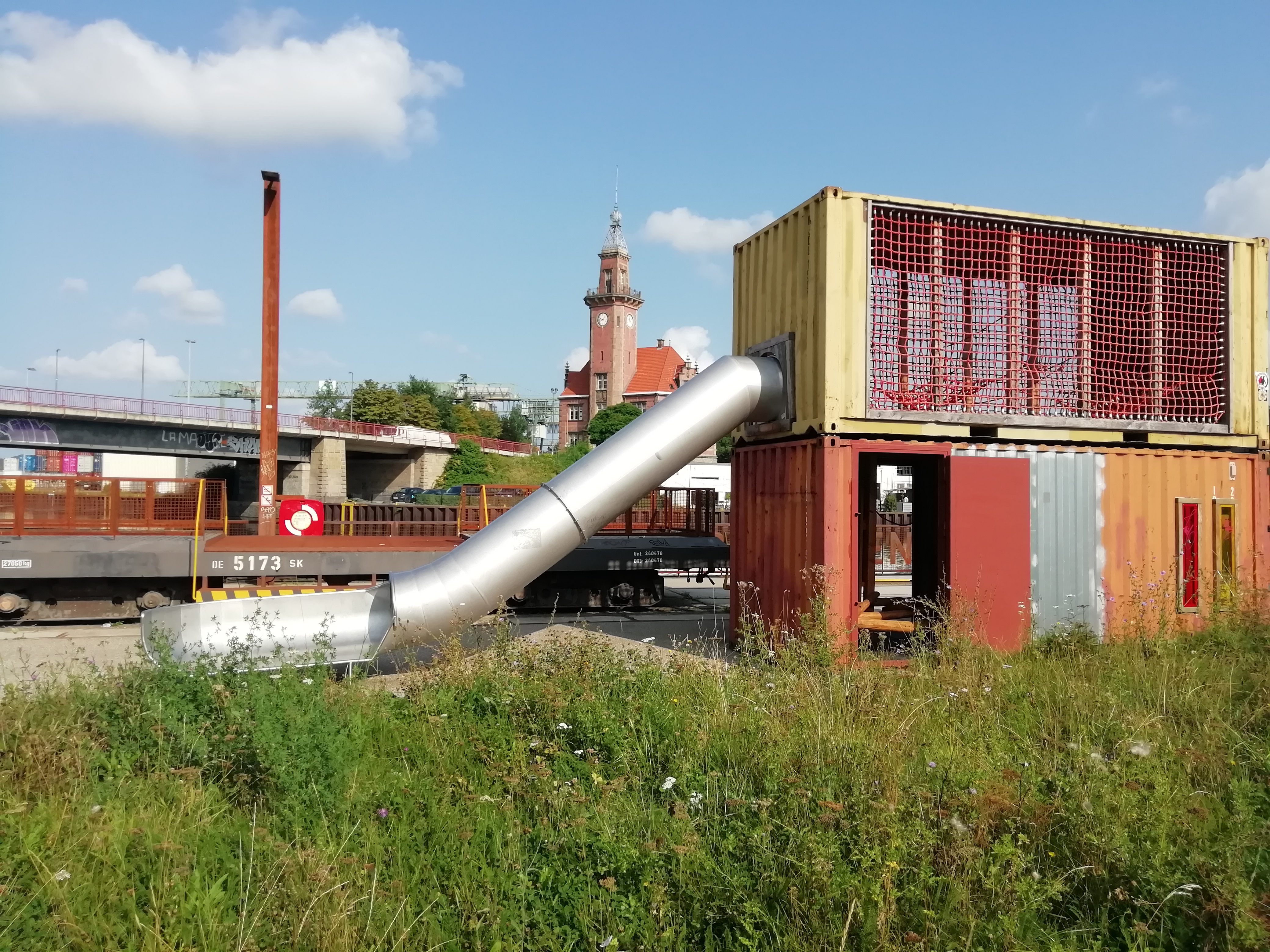 Umfunktionierte Seecontainer mit Röhrenrutsche, im Hintergrund das Alte Hafenamt.