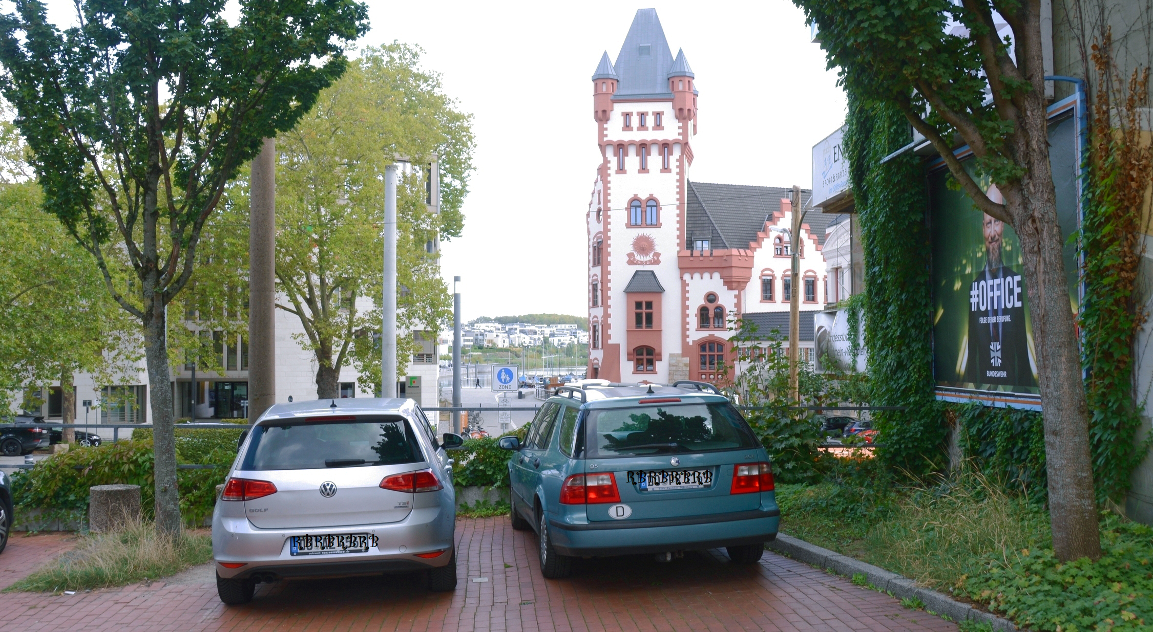 Foto der Hörder Burg in einiger Entfernung, im Vordergrund verdeckt durch zwei parkende Autos 