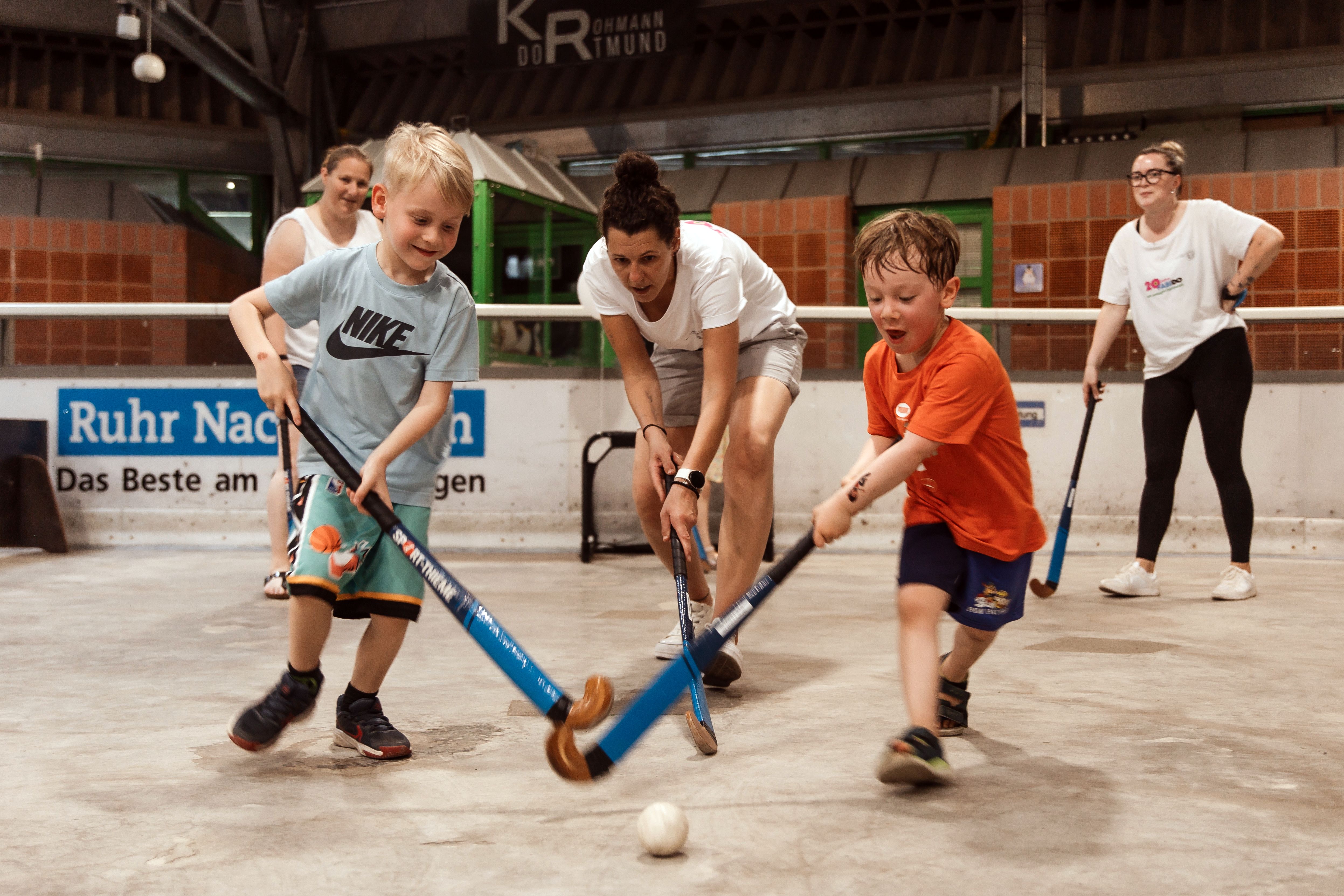Kinder beim Hockeyspielen.