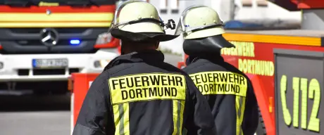 Zwei Feuerwehrangehörige vor einen Löschfahrzeug