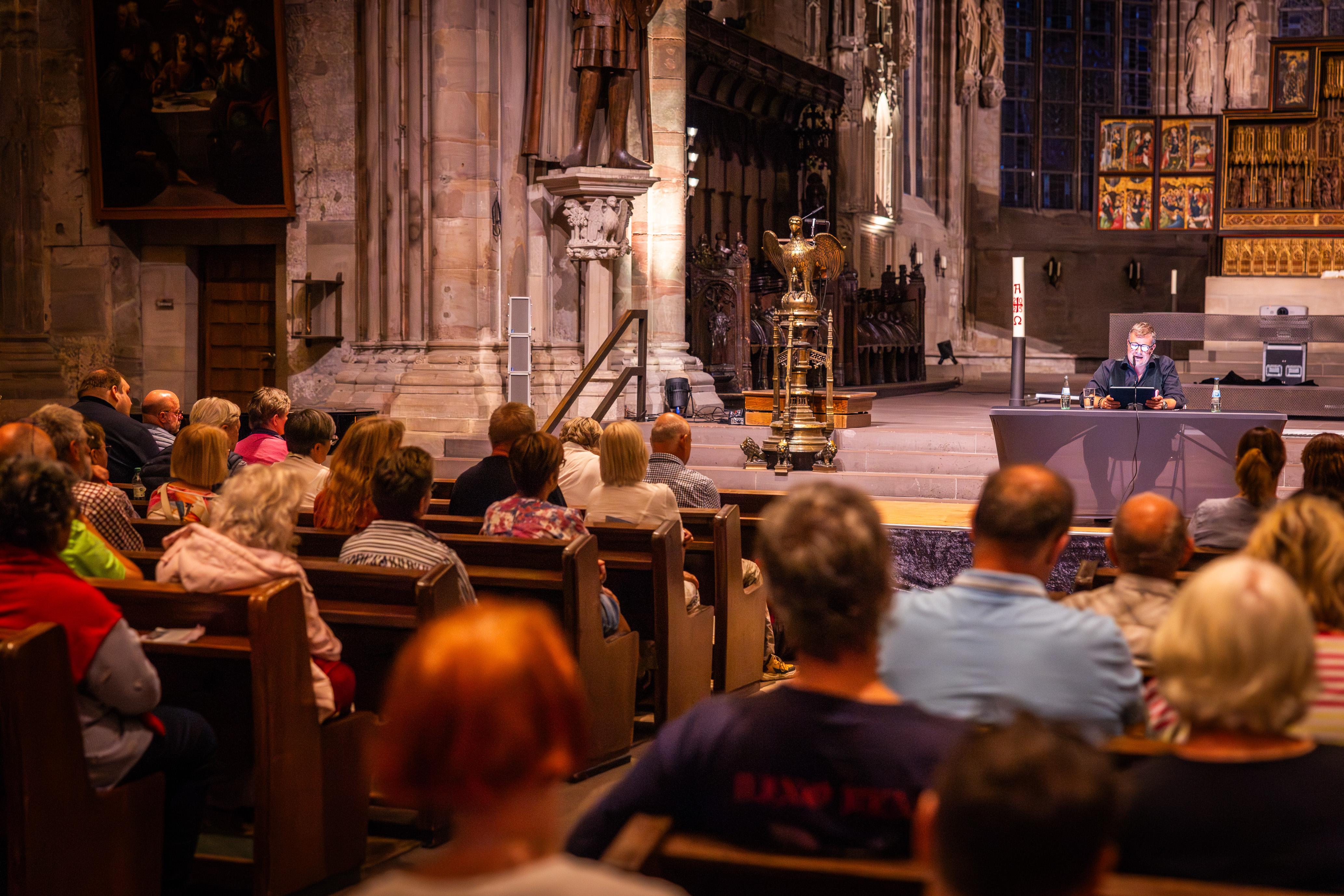 Kirchensaal der Reinoldikirche. Die SItzreihen sind gefüllt, auf der Bühne vorne liest ein Autor