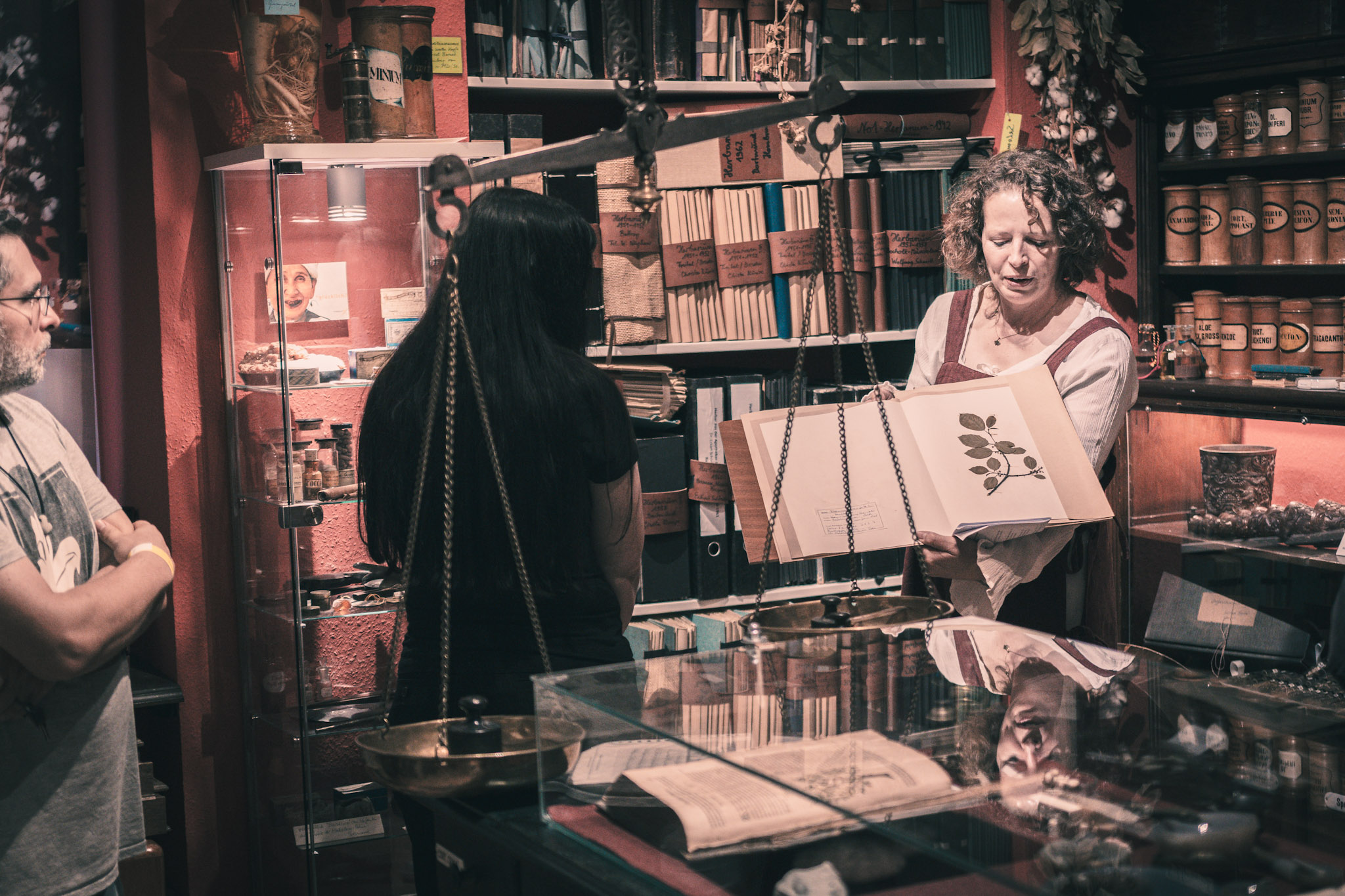 Besucher*innen und Guide in der Ausstellung des Apotheken-Museums zwischen zahlreichen historischen Arzneien und Exponaten.