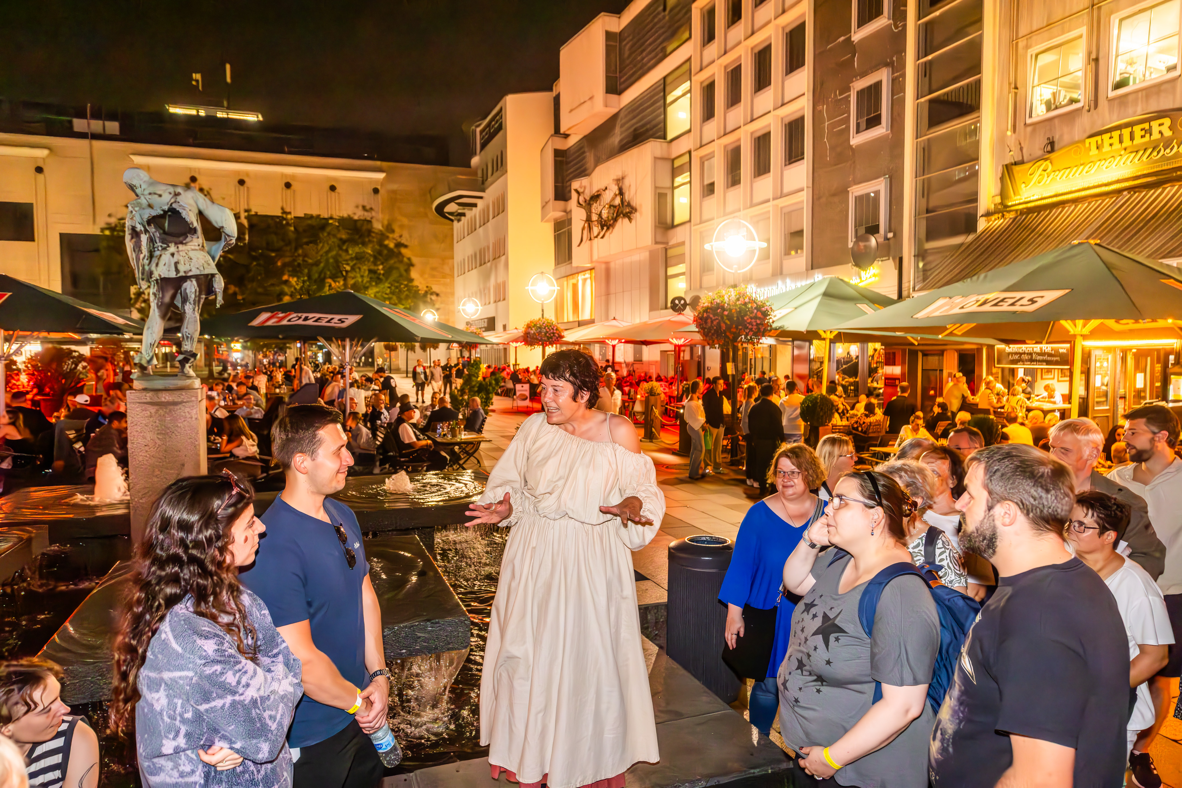 Guide im historischen Gewand vor einer Personengruppe bei einer Stadtführung durch die Innenstadt.