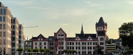 Zu sehen ist die rot-weiße Hörder Burg bei Einbruch des Abends. Sie spiegelt sich auf der Hafen-Seite im Phönix See.