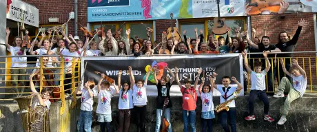 Gruppenfoto der Schüler*innen von Dortmund Musik vor dem Gebäude der Musikschule. 