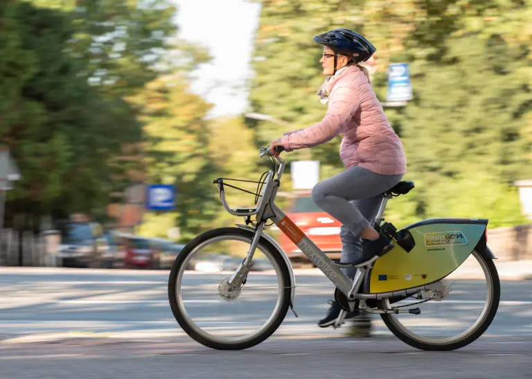 Eine Person fährt mit einem metropolradruhr Fahrrad eine Straße entlang.