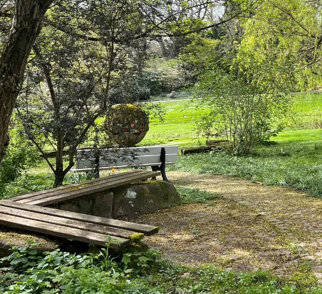 Wegbiegung mit Sitzbank im Grünen