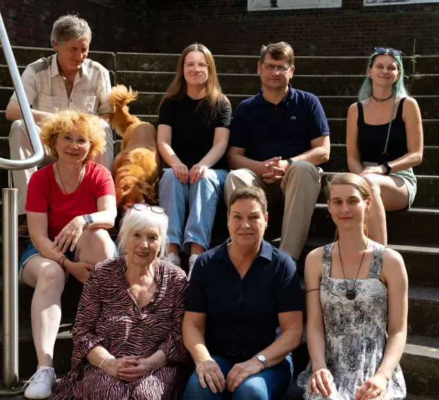 Die "Killer Ladys"-Truppe vom Gehörlosen Theaterverein Dortmund e.V. sitzt auf einer Treppe